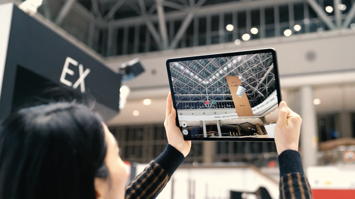 Woman testing the AR solution demo on a tablet at NRF 2023.